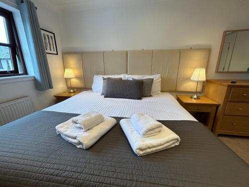 a bedroom with a bed with two towels on it at Principal Apartments - Merchant City in Glasgow