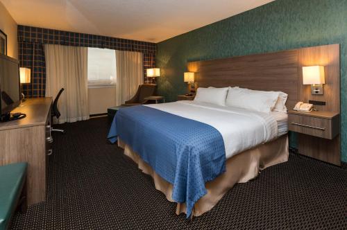 a hotel room with a large bed and a television at Holiday Inn Des Moines-Downtown-Mercy Campus by IHG in Des Moines