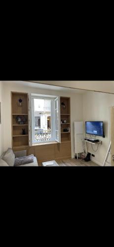 uma sala de estar com uma janela e uma televisão em Appart au cœur de Bastille em Paris