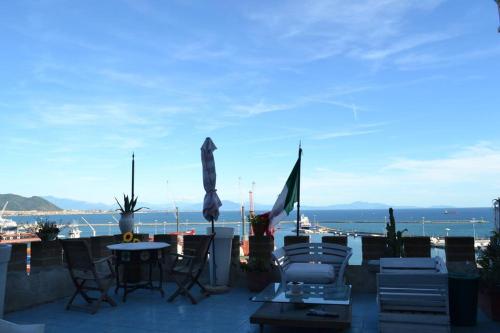 a patio with chairs and tables and a view of the ocean at B&B Charming House in Salerno