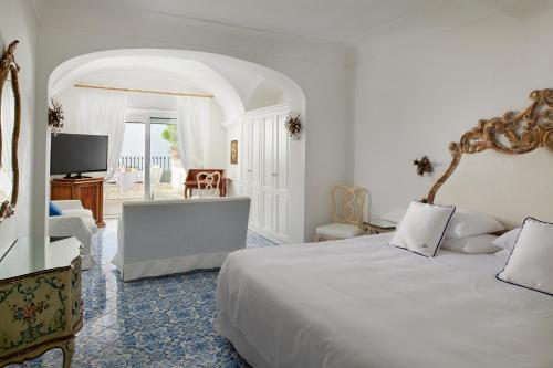 a bedroom with a large bed and a living room at Hotel Scalinatella in Capri
