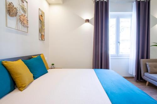 a bedroom with a large bed with blue and yellow pillows at ML Apartment Cagliari in Cagliari