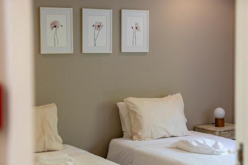 a bedroom with two beds and three pictures on the wall at Casa dos Pinheiros 109 - Private Villa with pool & heated SPA in Porto