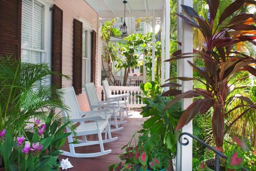 a porch with white chairs and plants on a house at Key West Bed and Breakfast in Key West
