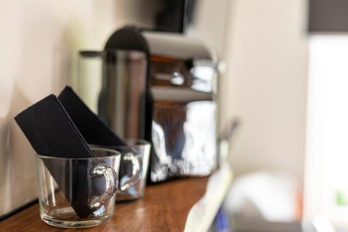 a wooden table with two cups with napkins in them at la chocolaterie in Roly