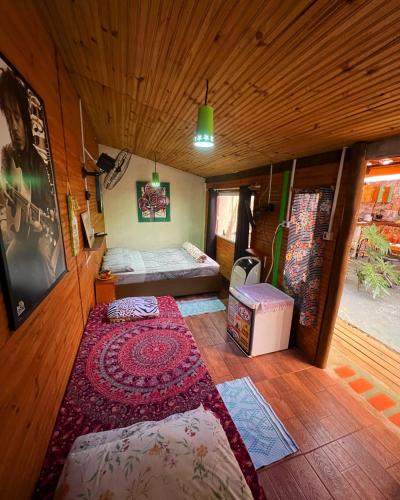 a room with a bed and a rug on the floor at hospedagem bicho do mato arts in Brotas