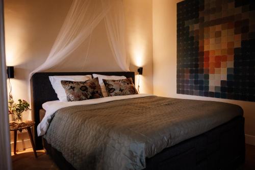 a bedroom with a large bed with curtains and pillows at Heeren van Acquoy in Acquoy