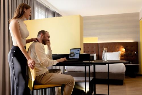 a woman standing next to a man in a hotel room at Pullman Santiago El Bosque in Santiago