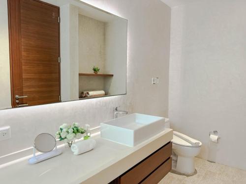 a bathroom with a white sink and a mirror at Increíble estudio G204 con gimnasio incluido by Sandy Powerful in Tulum