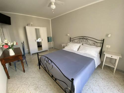 een slaapkamer met een bed, een tafel en een spiegel bij Dimora Bro in Conversano
