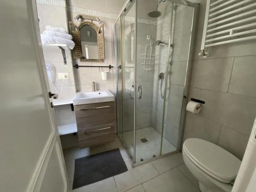 een badkamer met een douche, een toilet en een wastafel bij Dimora Bro in Conversano