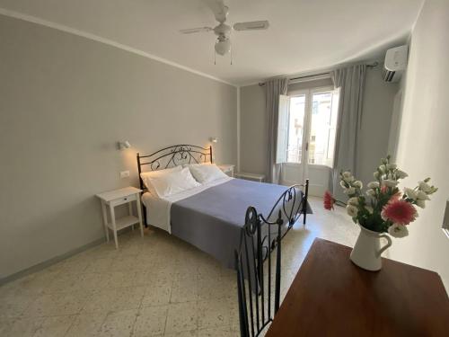 een slaapkamer met een bed en een vaas met bloemen bij Dimora Bro in Conversano
