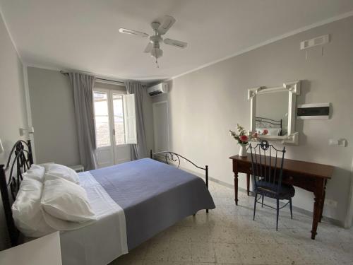 een slaapkamer met een bed, een bureau en een spiegel bij Dimora Bro in Conversano