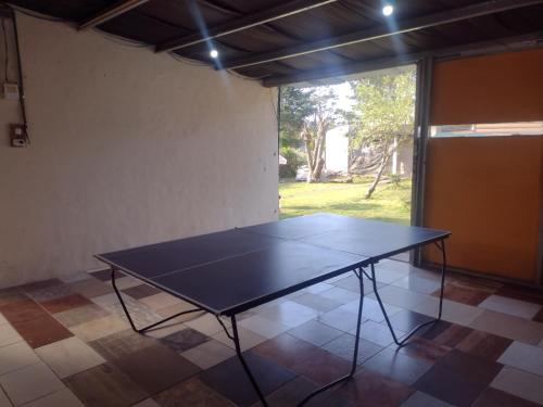 a ping pong table in a room with a window at Casa Los Acantilados in Mar del Plata