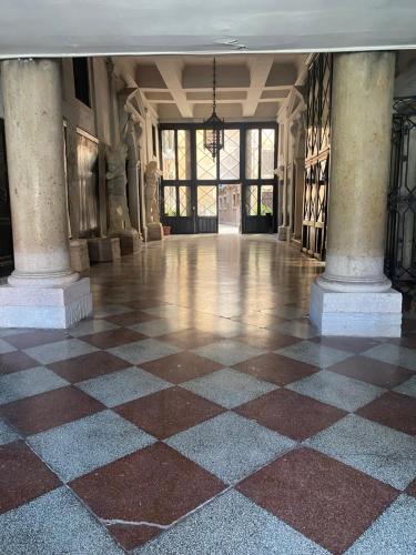 a large room with a checkered floor and large windows at Dimora Contarini Charm Apartment on Grand Canal in Venice