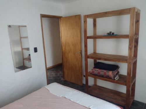a bedroom with a wooden book shelf next to a bed at Casa Los Acantilados in Mar del Plata