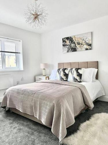 a white bedroom with a large bed and a window at Harmony home Lindley Huddersfield in Lindley