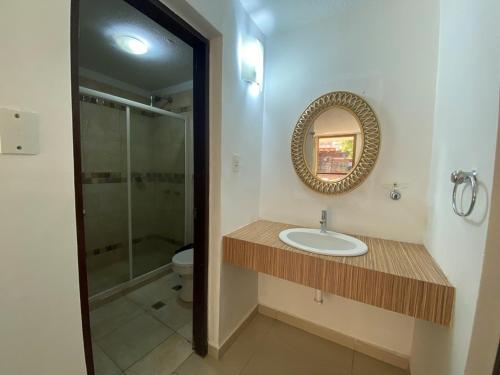 a bathroom with a sink and a shower and a mirror at DYNASTY A002 in Porlamar