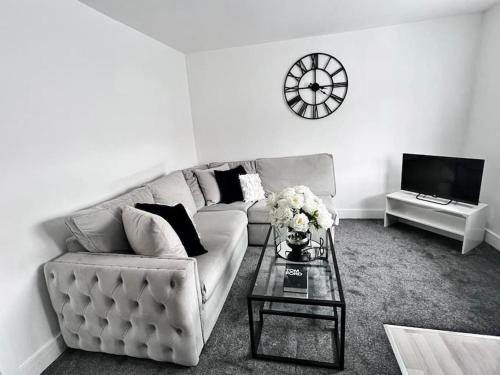 ein Wohnzimmer mit einem Sofa und einem Tisch in der Unterkunft Harmony home Lindley Huddersfield in Lindley