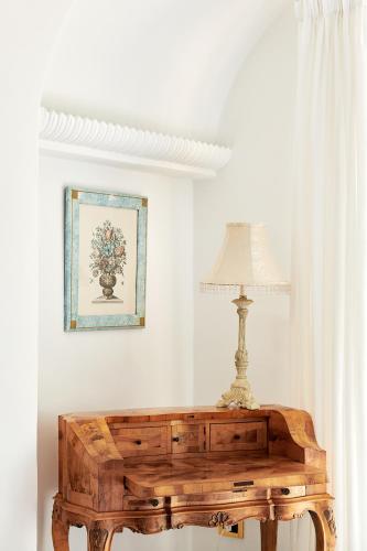 a lamp on top of a wooden table in a room at Hotel Scalinatella in Capri