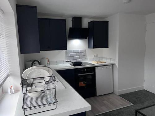 a kitchen with black cabinets and a white counter top at Harmony home Lindley Huddersfield in Lindley