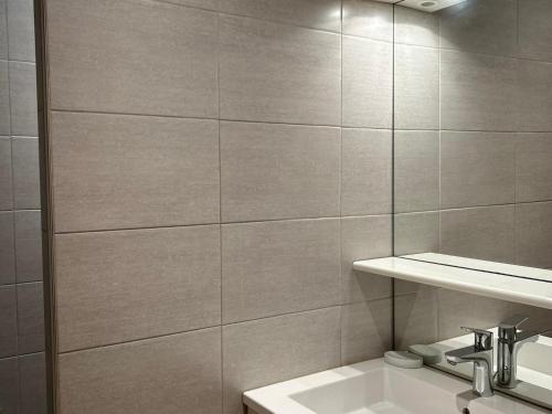 une salle de bain blanche avec un lavabo et un miroir dans l'établissement Les Gets - Appartement rénové proche pistes, navette gratuite, parking - FR-1-623-114, aux Gets