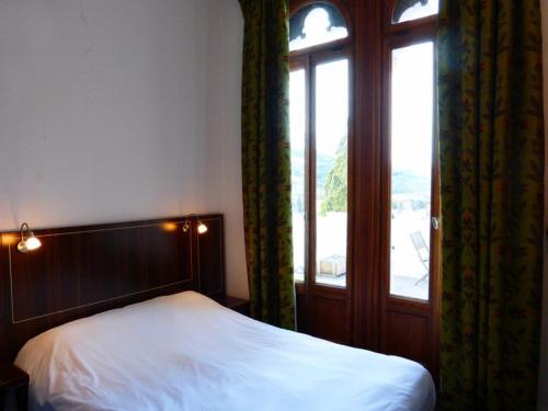 sypialnia z łóżkiem i dużym oknem w obiekcie Appartement Standing Château des Magnans w mieście Jausiers