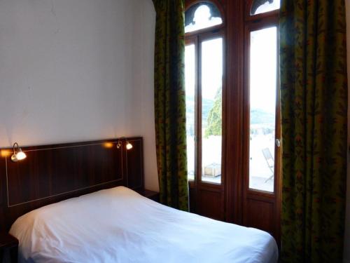 a bedroom with a bed and a large window at Appartement Standing Château des Magnans in Jausiers