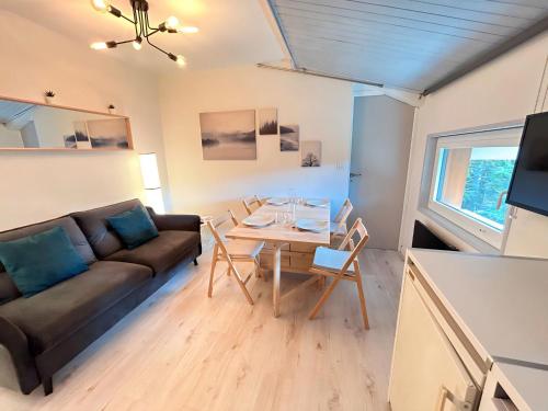 un salon avec un canapé et une table dans l'établissement Appartement rénové aux Gets, proche pistes et lac, avec parking, navettes gratuites et accepte animaux - FR-1-623-266, aux Gets