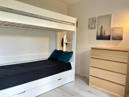 - une chambre avec des lits superposés et des oreillers bleus dans l'établissement Appartement rénové aux Gets, proche pistes et lac, avec parking, navettes gratuites et accepte animaux - FR-1-623-266, aux Gets