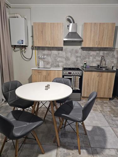 a kitchen with a white table and four chairs at New apartment 1 in Lviv
