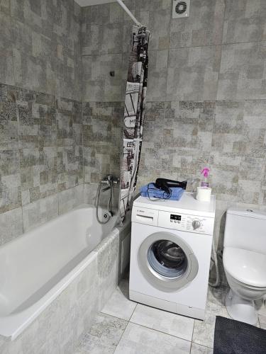 a bathroom with a washing machine and a toilet at New apartment 1 in Lviv