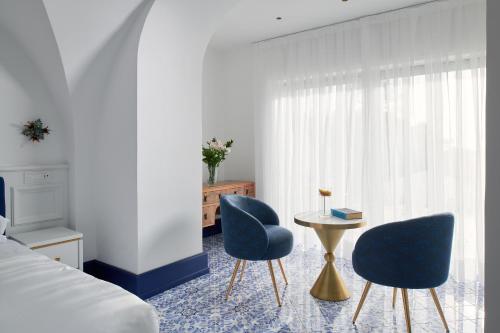 a bedroom with two chairs and a table and a bed at Hotel Scalinatella in Capri