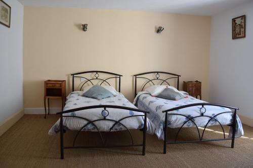 two beds sitting next to each other in a bedroom at Le Jardin Secret in Saint-Antonin