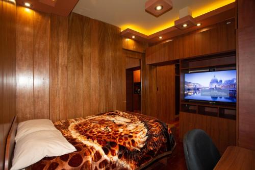 1 dormitorio con 1 cama y TV en Modernos Departamentos - Lake Titicaca Puno, en Puno