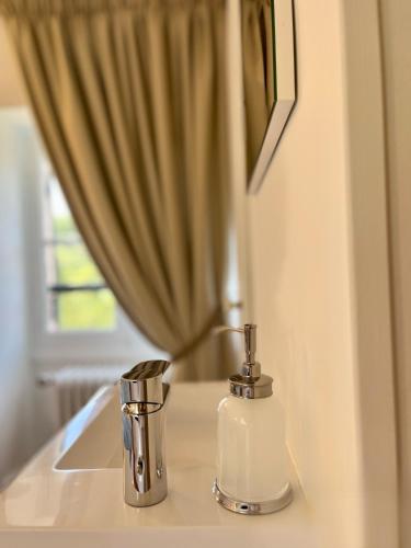 a soap dispenser sitting on a counter next to a mirror at Richard Lequet Domaine gastronomique du Val d Atur in Boulazac