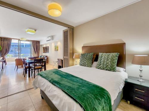 Un dormitorio con una cama grande y un comedor. en Soak up canal views, Walk to V&A Waterfront and CTICC, en Ciudad del Cabo