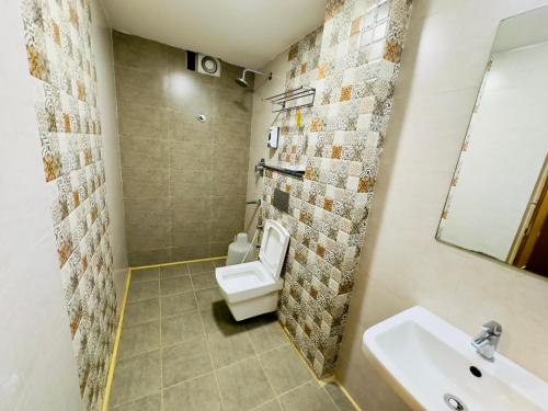 a bathroom with a toilet and a sink at Sheraton Grande at Puratchi Thalaivar Dr MGR Central Railway Station in Chennai