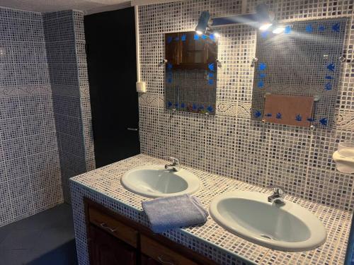 La salle de bains est pourvue de 2 lavabos et d'un miroir. dans l'établissement La villa Creole - location saisonnière Cilaos, à Cilaos