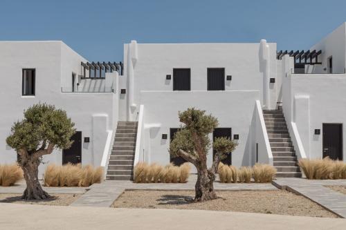 um edifício branco com árvores em frente em Laguna Suites in Mazera Mykonos em Míconos