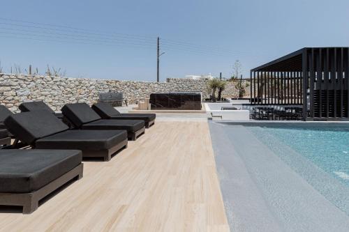 a pool with couches and a fireplace next to afficiency at Laguna Suites in Mazera Mykonos in Mýkonos City