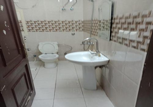 a white bathroom with a toilet and a sink at الحمدانية الراقي للأجنحة الفندقية in Jeddah
