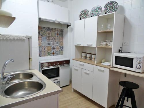 eine Küche mit einer Spüle und einer Mikrowelle in der Unterkunft El Zoco in Baños de la Encina