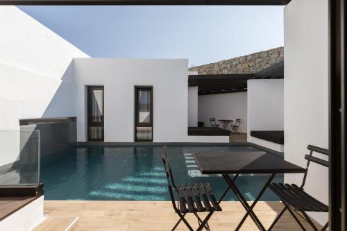 a swimming pool with a table and chairs in a house at Laguna Suites in Mazera Mykonos in Mýkonos City
