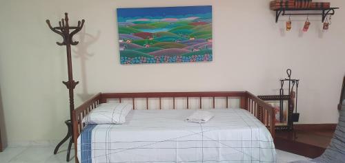 Ce lit se trouve dans un dortoir orné d'une peinture murale. dans l'établissement Pousada Morada dos Pássaros, à Pedro Leopoldo