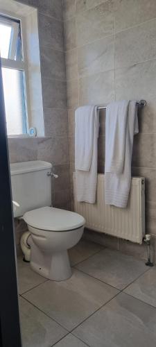 uma casa de banho com um WC branco e toalhas em Jake's Place em Doolin