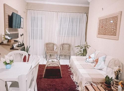 a living room with a couch and chairs and a window at Apartamento encantador em Lagoinha Paraipaba/CE in Tigre