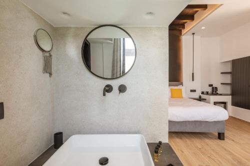 a bathroom with a white sink and a mirror at Laguna Suites in Mazera Mykonos in Mýkonos City
