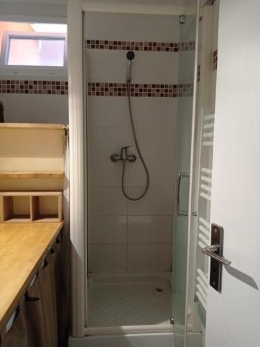 une douche avec une porte vitrée dans une salle de bain dans l'établissement Foudebassan, à La Teste-de-Buch