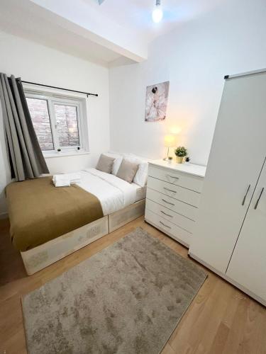Cosy Stunning Flat في لندن: غرفة نوم صغيرة بها سرير ونافذة